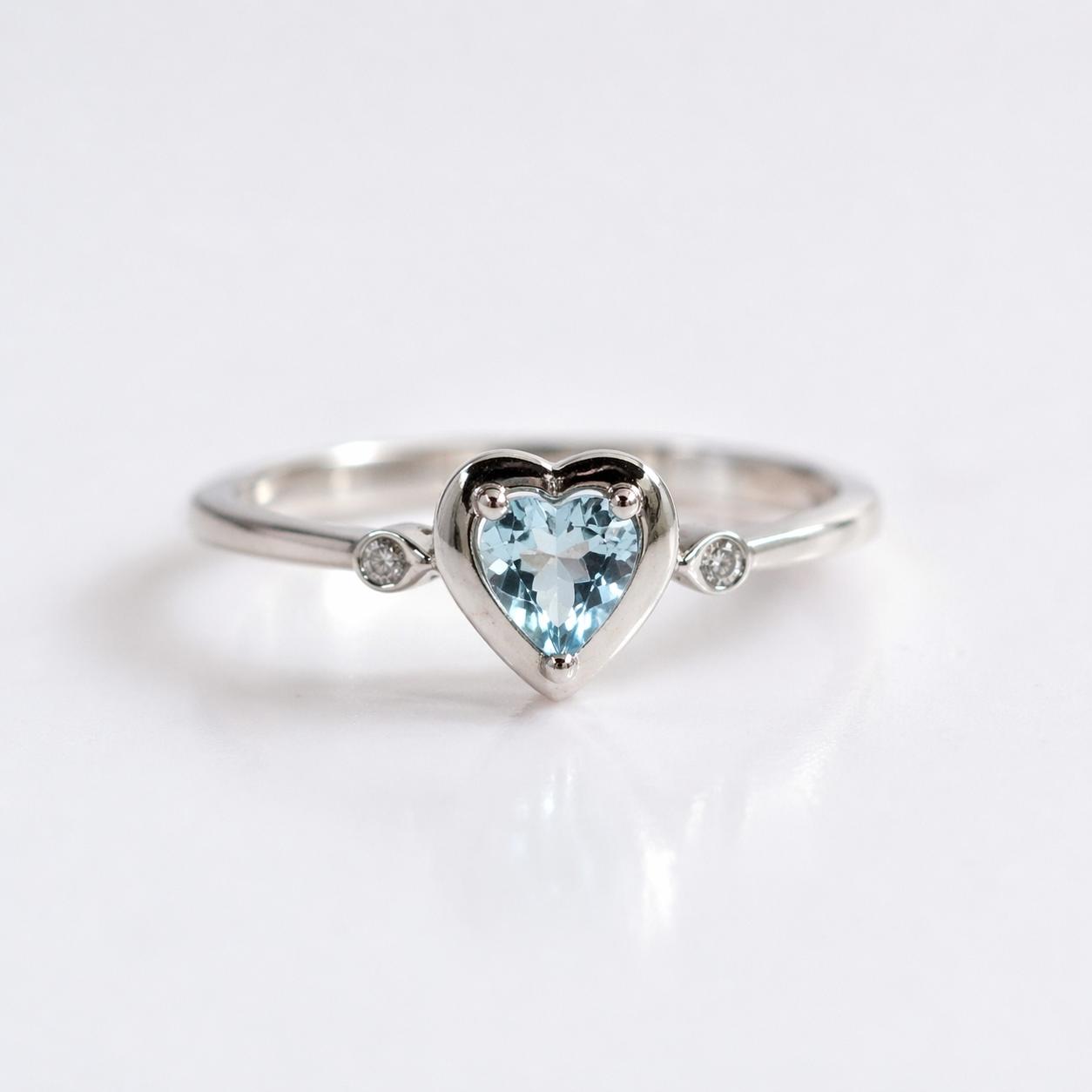 ANELLO IN ORO 9KT, BIANCO CON DIAMANTINI LATERALI E CUORE ACQUAMARINA