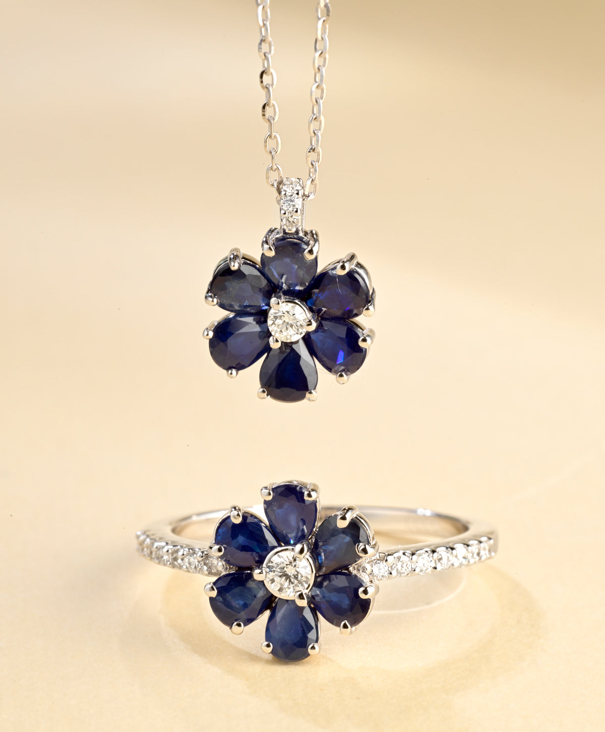 CIONDOLO A FIORI IN ORO BIANCO CON DIAMANTE CENTRALE E ZAFFIRI