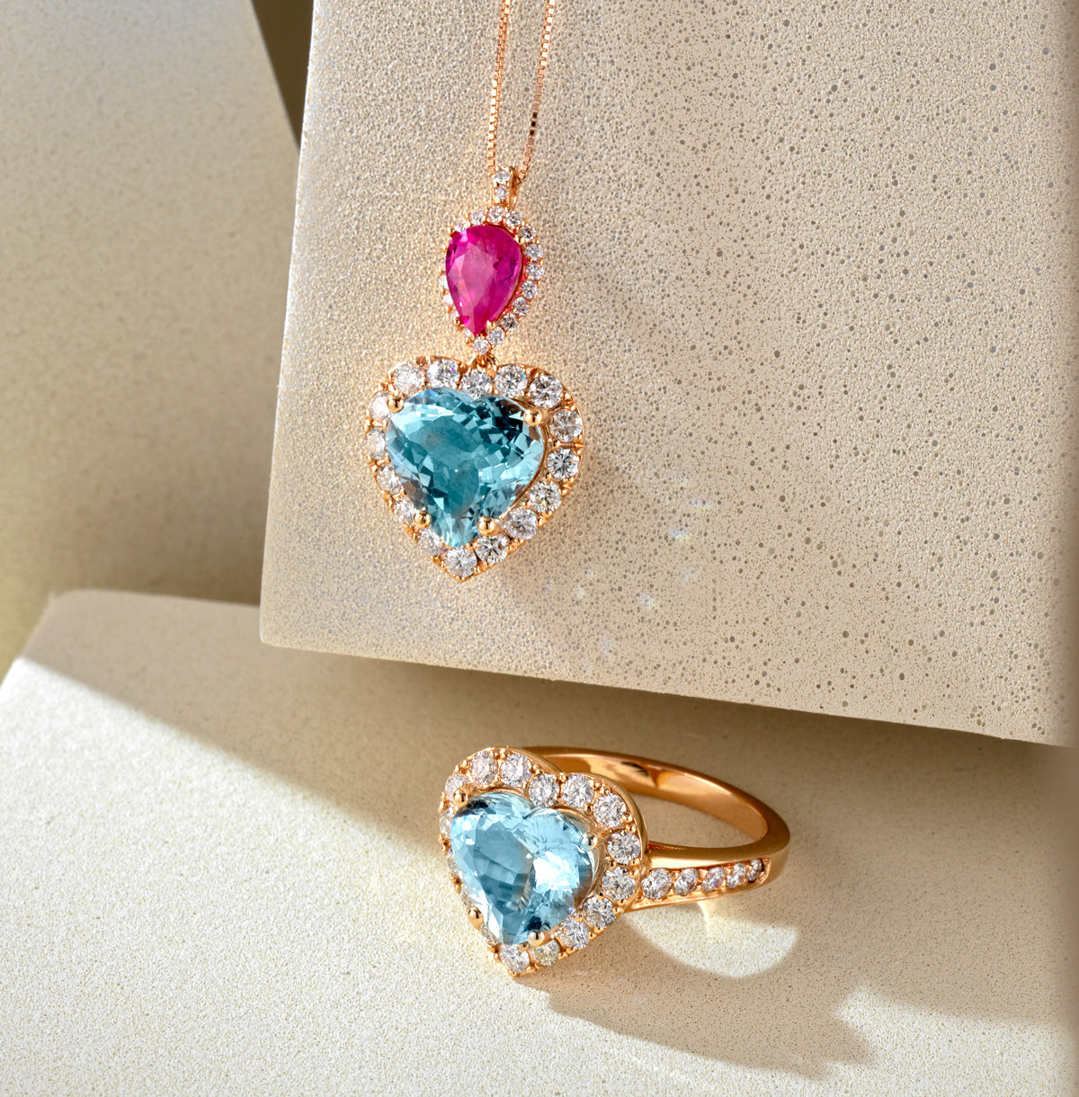 CIONDOLO IN ORO ROSA DI DIAMANTI CON GOCCIA DI RUBINO E CUORE ACQUAMARINA PENDENTE