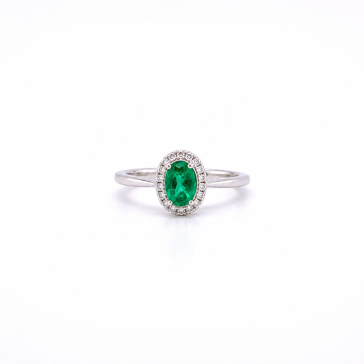 ANELLO IN ORO BIANCO, CON DIAMANTI E OVALE SMERALDO  CENTRALE