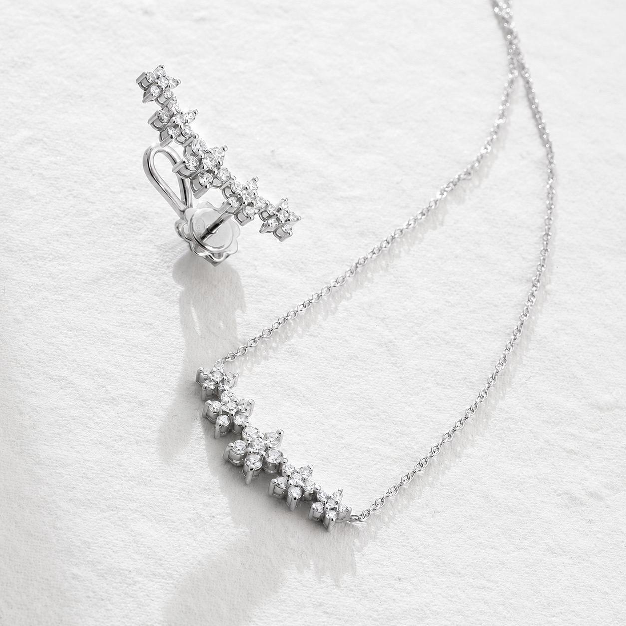 MONO ORECCHINO LUNGO IN ORO BIANCO CON FIORI DI DIAMANTI