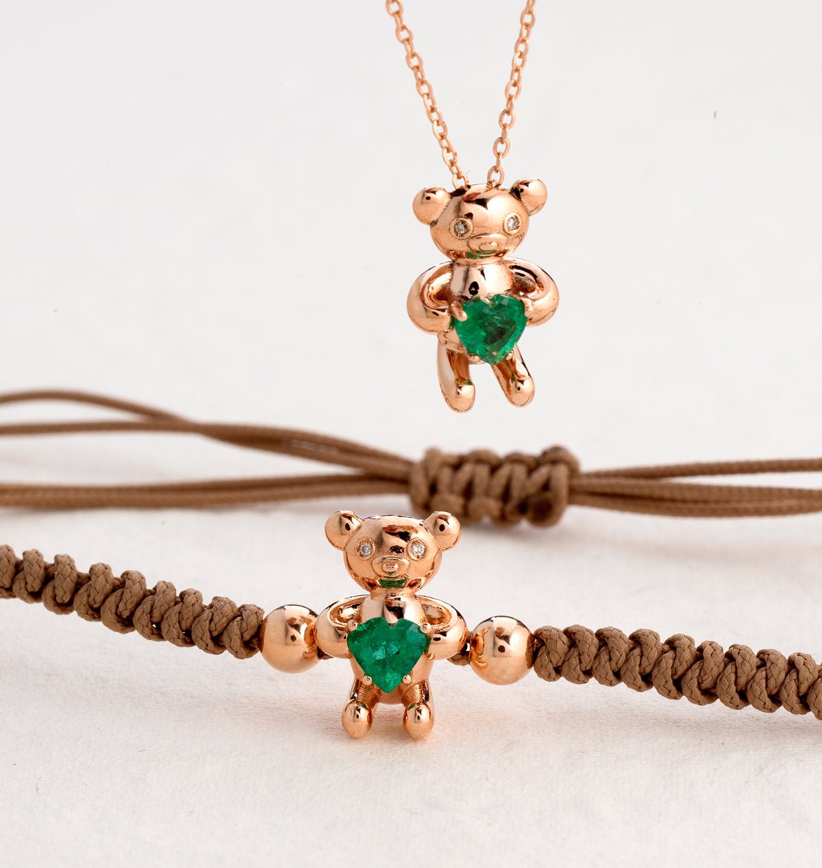 BRACCIALE ORSETTO IN ORO ROSA CON CUORE DI SMERALDO E LACCIO MARRONE