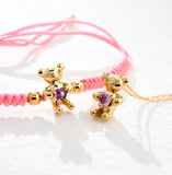 BRACCIALE ORSETTO IN ORO GIALLO CON CUORE DI ZAFFIRO ROSA E LACCIO ROSA